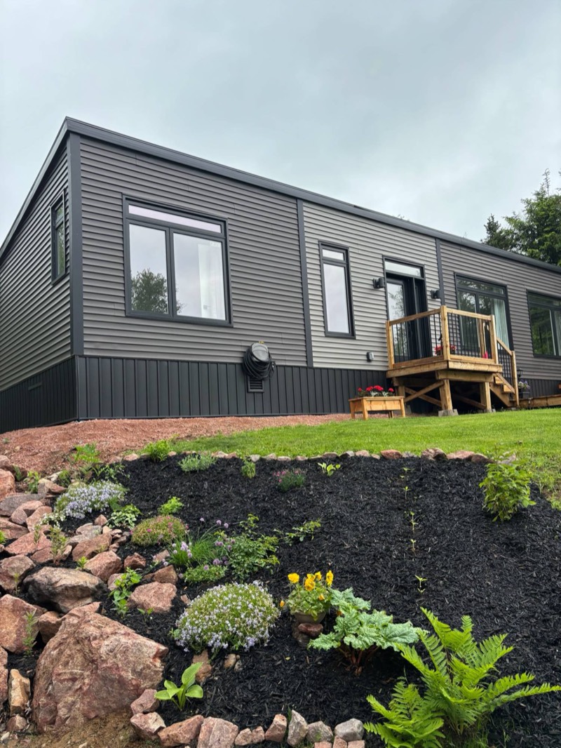 Tides and Trails Cottage, a modern charcoal-grey waterfront cottage with a rock garden near Parrsboro, Nova Scotia