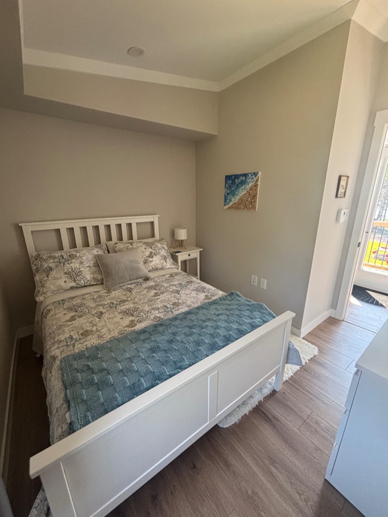 Second bedroom with a white double bed and a soft blue throw